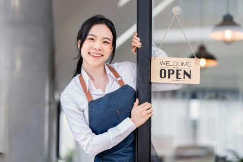 a staff helping to open a shop tapping onto the big glass window, 公司開張到會, 商務食物外賣, 一口派對小食, 公司機構活動派對到會, 辦公室生日到會, 高質外賣推介, Chinese party food catering, Canapes for parties, catering service for shop opening ceremony